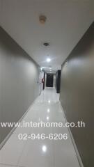 Hallway with white tile flooring and beige walls