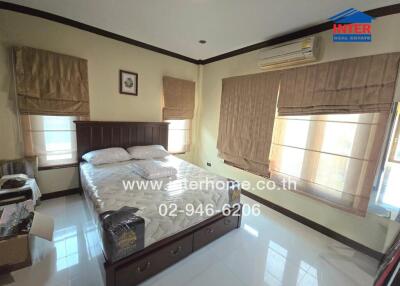 Bedroom with large bed, windows, and air conditioning