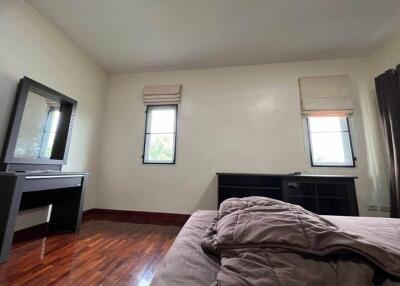 Spacious bedroom with hardwood floors and large windows