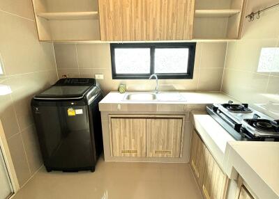 Modern kitchen with stove, sink, and washing machine