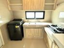 Modern kitchen with stove, sink, and washing machine