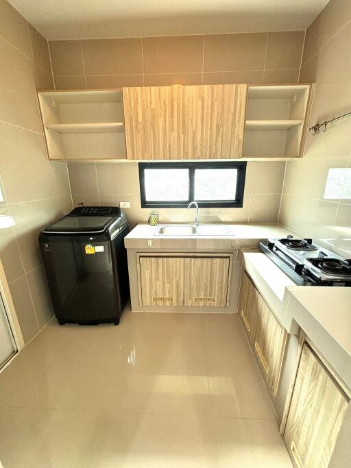 Modern kitchen with stove, sink, and washing machine