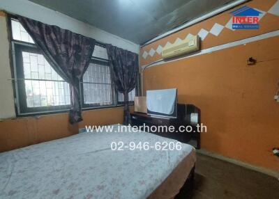 Bedroom with bed, air conditioning, and windows with curtains