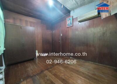 Wood-paneled bedroom with wardrobe and air conditioning