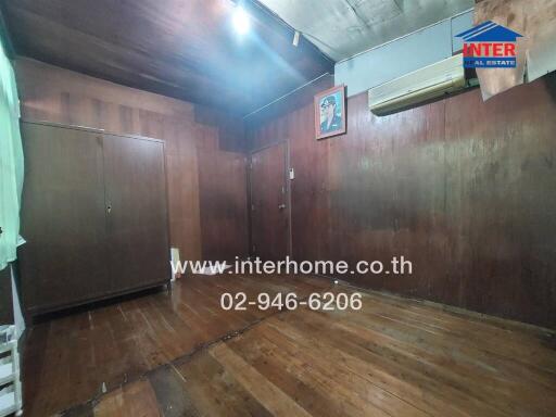 Wood-paneled bedroom with wardrobe and air conditioning