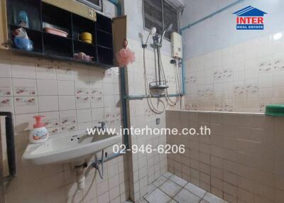 Bathroom with sink, shower, and storage shelves