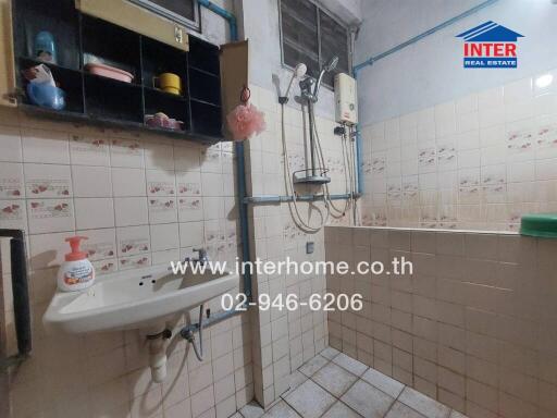 Bathroom with sink, shower, and storage shelves