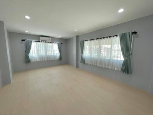 Spacious living room with large windows and curtains