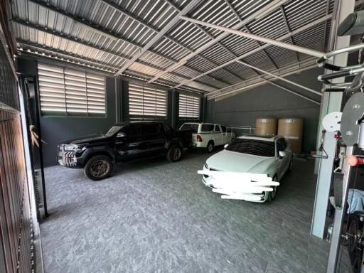 Spacious garage with three parked cars and structured metal roof