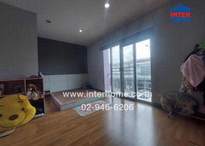 Bedroom with wooden flooring and sliding glass doors