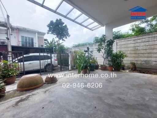 Covered outdoor area with potted plants and a view of the street