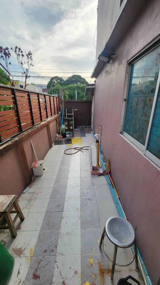 Balcony with various items including stool and cleaning equipment