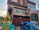 Three-story house with driveway and car