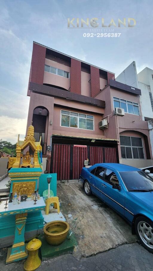 Three-story house with driveway and car