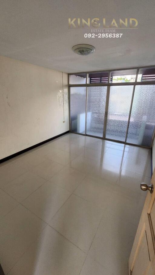 Empty room with tiled floor and large windows