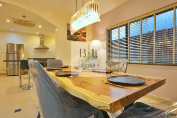 Modern kitchen and dining area with wooden dining table and pendant light