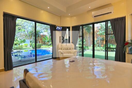 Bedroom with pool view and large windows