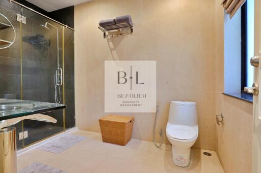 Modern bathroom with shower, toilet, and wicker basket