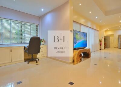 Spacious living area with desk and TV