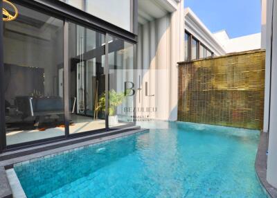 Modern pool area with glass sliding doors and bamboo wall