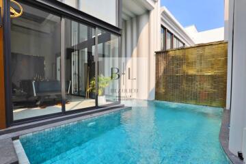 Modern pool area with glass sliding doors and bamboo wall