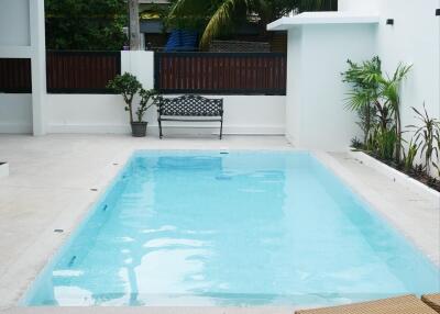 Outdoor pool area with lounge chairs and fruit basket