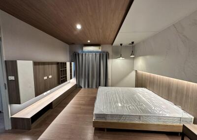 Modern minimalist bedroom with wooden flooring and ceiling