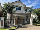 Front view of a two-story house with a gated entrance