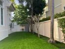 Well-maintained backyard with artificial grass and trees