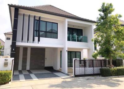 Modern two-story house with large windows and a balcony