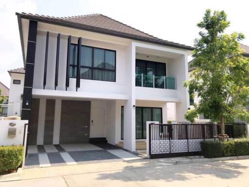 Modern two-story house with large windows and a balcony