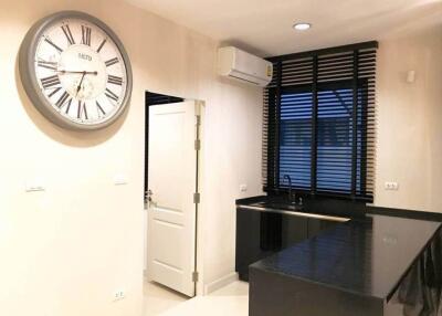 Modern kitchen with large wall clock and black countertops