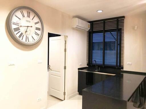 Modern kitchen with large wall clock and black countertops