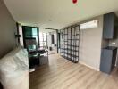 Modern living room with wooden flooring, air conditioning, and floating shelves