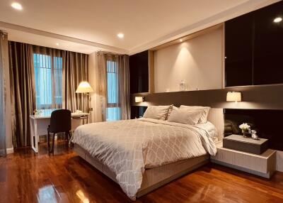 Cozy bedroom with a large bed, wooden flooring, and a desk