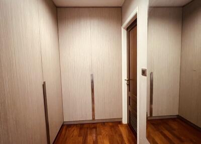 Spacious walk-in closet with wooden flooring and built-in cabinets