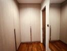 Spacious walk-in closet with wooden flooring and built-in cabinets