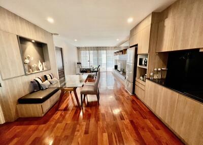 Modern open-concept living room and kitchen with hardwood floors and integrated dining area