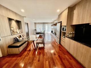 Modern open-concept living room and kitchen with hardwood floors and integrated dining area