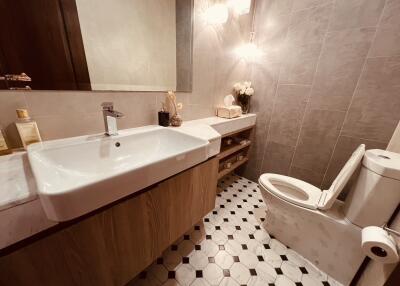 Modern bathroom with sink, toilet, and tiled walls