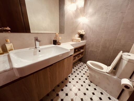 Modern bathroom with sink, toilet, and tiled walls