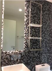 Modern bathroom with mosaic tile wall and large mirror