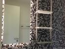 Modern bathroom with mosaic tile wall and large mirror