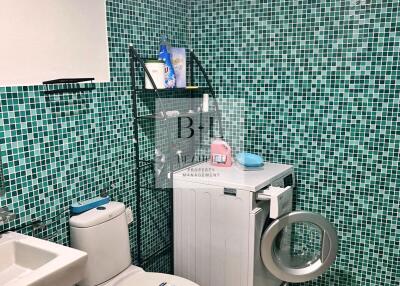 Bathroom with washing machine and green mosaic tiles