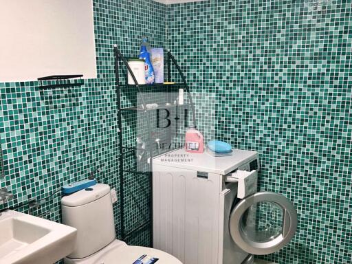 Bathroom with washing machine and green mosaic tiles