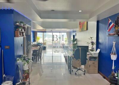 Modern living area with blue walls, desk, and large windows.