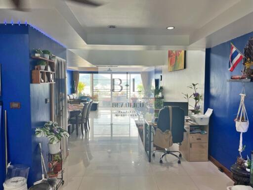 Modern living area with blue walls, desk, and large windows.