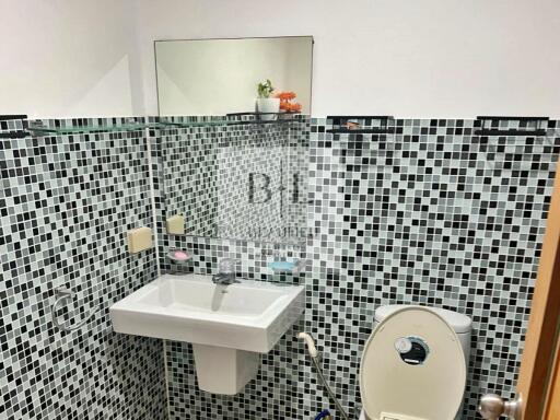 Modern bathroom with mosaic tiles and wall-mounted sink