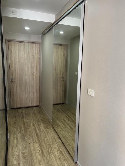 Hallway with wooden flooring and mirrored closet doors