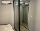 Modern bedroom with sliding mirrored wardrobe doors and air conditioning unit